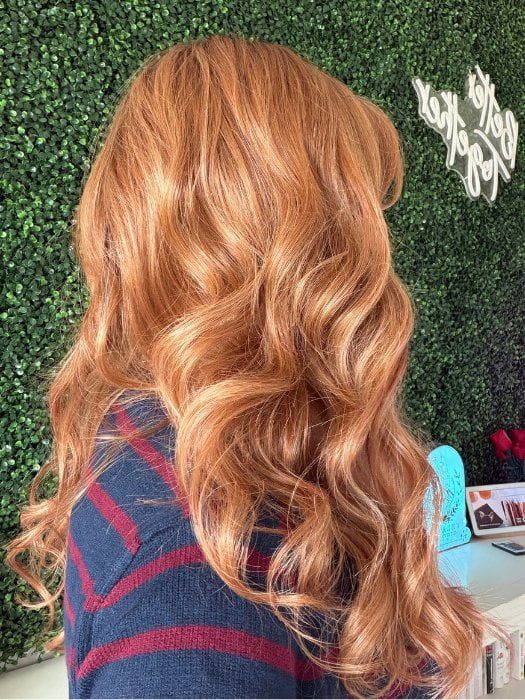 Carly wearing WITHERSPOON by BELLETRESS in MIXED BERRY R | A bold, berry-inspired red with deep auburn tones and soft rooting for a natural regrowth effect. 