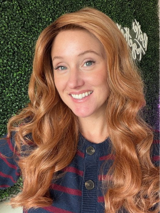 Carly wearing WITHERSPOON by BELLETRESS in MIXED BERRY R | A bold, berry-inspired red with deep auburn tones and soft rooting for a natural regrowth effect. 