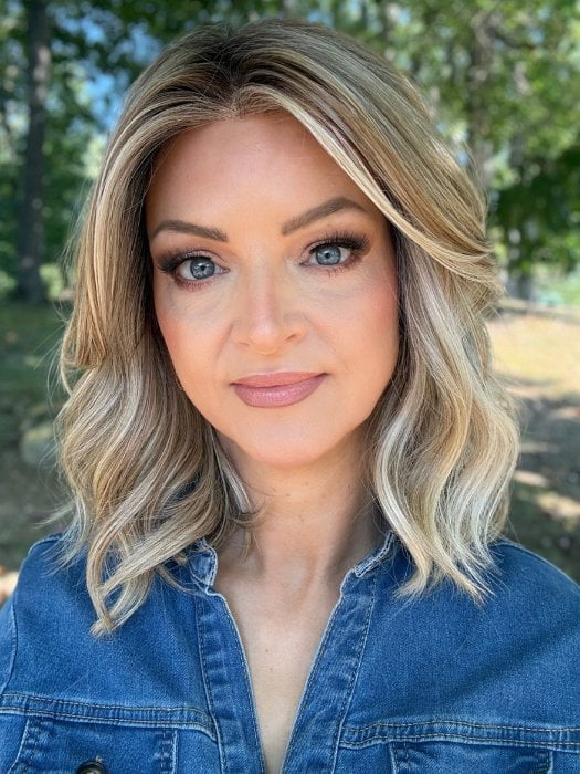 Sandy wearing BRADSHAW by BELLETRESS in BUTTERCAKE BLONDE-R | A neutral-warm blonde blend featuring light brown, ash, and lightest blonde tones with natural-looking darker roots for added depth and realism.