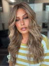 Roxie wearing KATNISS by BELLETRESS in BROWN SUGAR BLONDE-R | A warm, dimensional blend of medium brown and golden blonde highlights with natural-looking darker roots for depth and a sun-kissed finish.