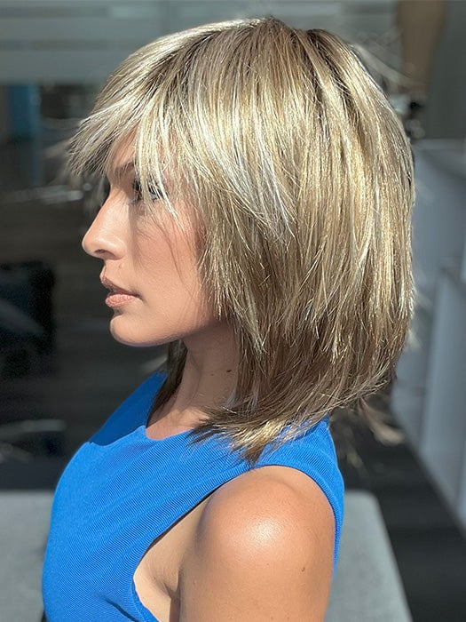 Model is wearing RAINBOW by ELLEN WILLE in color SAND MULTI ROOTED 14.24.12 | Medium Ash Blonde, Lightest Ash Blonde, and Lightest Brown Blend with Dark Shaded Roots