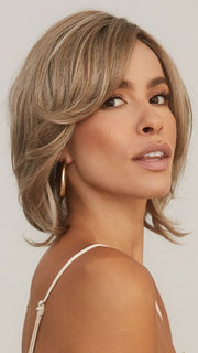 Model is wearing SHEENA by RENE OF PARIS in color CHAMPAGNE SUNSET | Dark/medium multi-tonal blond with textured honey, ash, and golden hues and chocolate brown roots