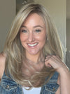 Carlyn @carlynwilson84 wearing SPEARS by BELLE TRESS in color BUTTERCAKE BLONDE-R | A neutral-warm blonde blend featuring light brown, ash, and lightest blonde tones with natural-looking darker roots for added depth and realism.