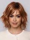 Model is wearing Terra by Amore in color  RUSTY-SUNRISE-R | Dark brown roots transition into a deep auburn tone with light copper blonde highlights for depth and dimension.