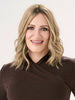 Model is wearing BARELY THERE WAVY 12" TOPPER in color PROSECCO | BROWN ROOTS WITH GOLDISH BLONDE HIGHLIGHTS
