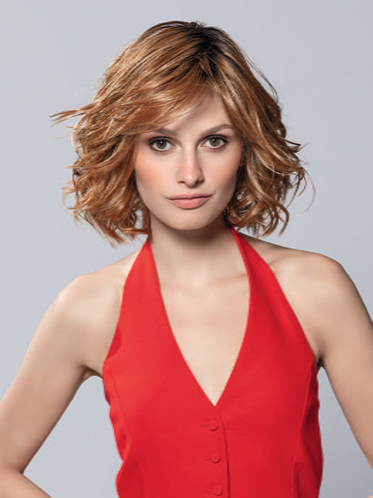 Model is wearing ELLE MONO by ELLEN WILLE in color PUMPKIN ROOTED | Dark Strawberry Blonde with Light Reddish Auburn and Copper Red Blend With Shaded Roots