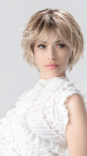 Model is wearing ESCAPE SOFT by ELLEN WILLE in color CANDY BLONDE ROOTED 101.27.60 | Pearl Platinum, Dark Strawberry Blonde and Pearl White with Shaded Roots