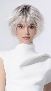 Model is wearing ESCAPE SOFT by ELLEN WILLE in color SILVER BLONDE ROOTED 60.1001.24 | Pearl White and Winter White with Lightest Ash Blonde Blend and Shaded Roots