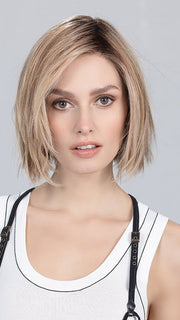 Model is wearing READY by ELLEN WILLE in color SAND MULTI ROOTED | Lightest Brown and Light Neutral Blonde with Light Reddish Auburn Blend and Shaded Roots