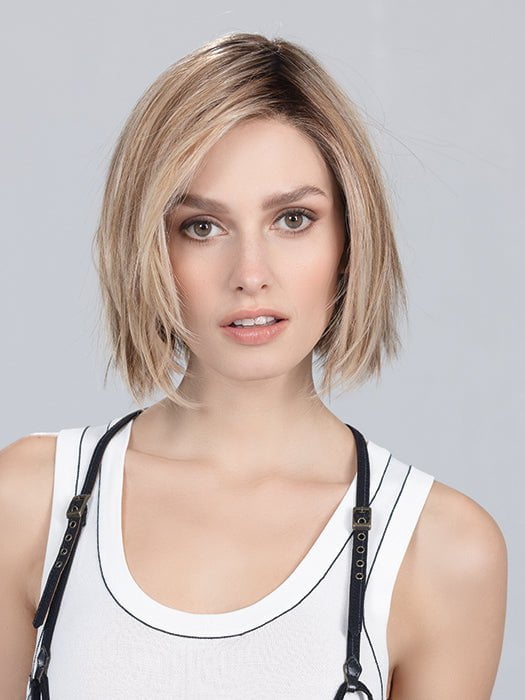Model is wearing READY by ELLEN WILLE in color SAND MULTI ROOTED | Lightest Brown and Light Neutral Blonde with Light Reddish Auburn Blend and Shaded Roots