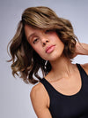 Model is wearing 10" AU NATUREL WAVES TOPPER in color SS9/24 ICED CAFÉ LATTE | Dark Brown shaded with Golden Brown