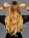 Model is wearing 19IN WAVY INVISIBLE EXTENSION by HAIRDO in color SS14/88H SHADED GOLDEN WHEAT | Dark Blonde Evenly Blended with Pale Blonde Highlights and Dark Roots