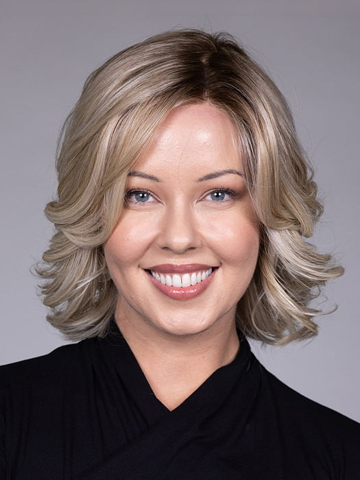 Model is wearing HELSINKI by BELLETRESS in color CRUSHED ALMOND BLONDE R | A soft Neutral Light Blonde with a Light and Medium Blended Root Color.