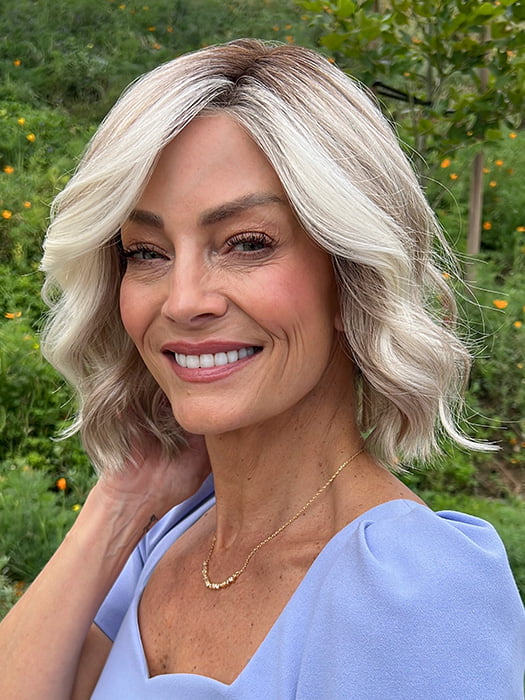 Model is wearing JANUARY PETITE by JON RENAU in color 101/88/27S8 CATALINA BLONDE | Pale blonde with Pure White Natural Violet halo highlights, shaded medium brown
