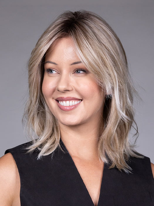 Model is wearing MONACO by BELLETRESS in color MILKSHAKE BLONDE R | A mixture of Light Sandy Brown, Highlighted with Light Ash Blonde with a Hint of Light Platinum Blonde with a Medium Root Color