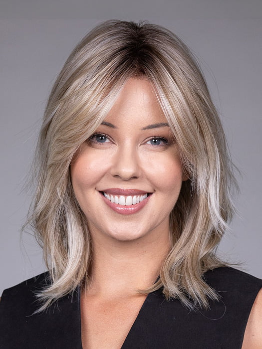 Model is wearing MONACO by BELLETRESS in color MILKSHAKE BLONDE R | A mixture of Light Sandy Brown, Highlighted with Light Ash Blonde with a Hint of Light Platinum Blonde with a Medium Root Color