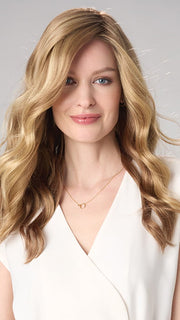 Model is wearing MAYA HAND TIED by ENVY in color SPARKLING CHAMPAGNE | Medium Brown roots with overall Strawberry Blonde base and soft Golden Blonde highlights