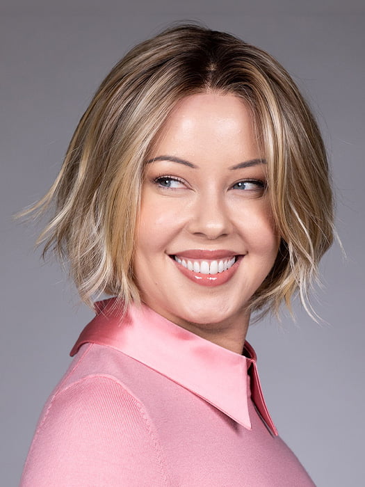 Model is wearing OSLO by BELLETRESS in color RAW SUGAR BLONDE | A Neutral Light Blonde, Honey Blonde, Pale Gold Blonde, with a base of Light Brown Lowlights featuring a Medium Root Color