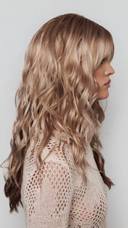 Model is wearing PHILLIPA by RENE OF PARIS in color WINTER OAT LATTE R | rooted honey blonde and platinum blonde blend with soft, dimensional highlights and lowlights