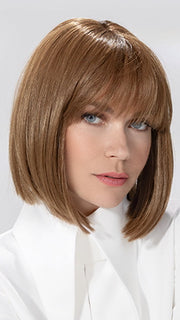 Model is wearing MISS COMFORT by ELLEN WILLE in color ALMOND BROWN ROOTED 830.9 | Medium Brown, Light Auburn and Medium Warm Brown Blend with Shaded Roots