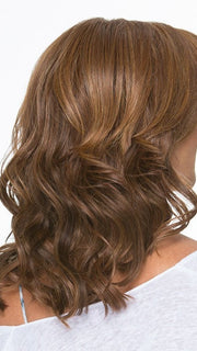 Soft silhouette with beach wave curl texture falls below the shoulders